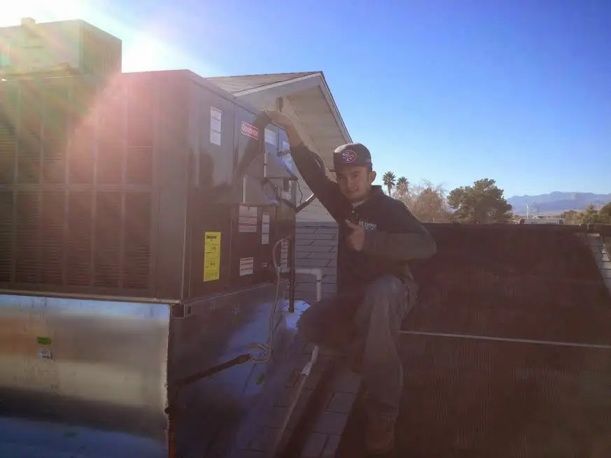HVAC technician performing Boiler Repair on a rooftop unit in Winton